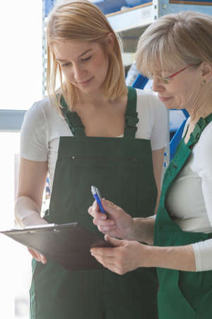 Competent lady shows her younger colleague the product listの写真素材