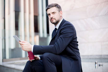 Picture of white collar worker with tablet laboring outsideの写真素材