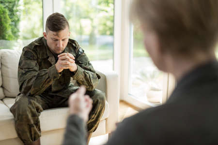 Image of depressed military man visiting psychologistの写真素材