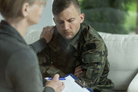Psychiatrist and despair military man during therapyの写真素材