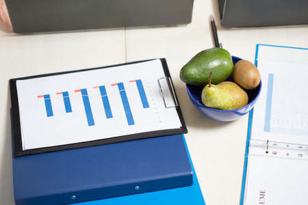 Close-up of desk with documents and snack at businessman's officeの写真素材