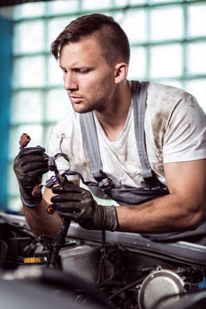 Portrait of focused automobile repair shop worker diagnosing problemの写真素材