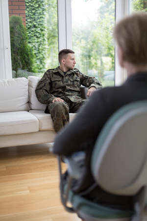 Young soldier having trauma during psychotherapy sessionの写真素材