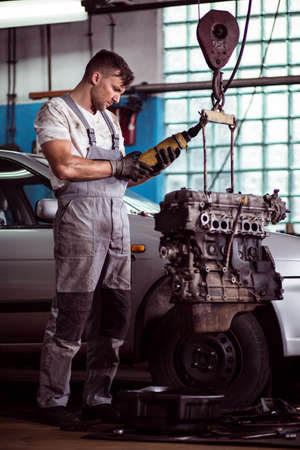 Picture of auto mechanic inspecting broken motor carの写真素材