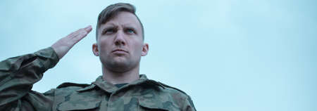 Young soldier is saluting to his commanderの写真素材