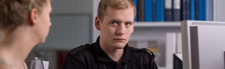 Police officer and suspected woman in the officeの写真素材