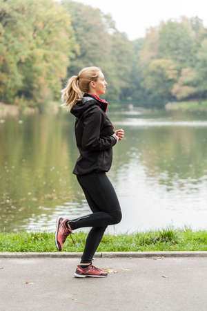 Blonde active woman running in beauty park