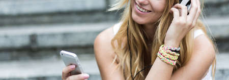 Young girl is listening music on her telephoneの写真素材