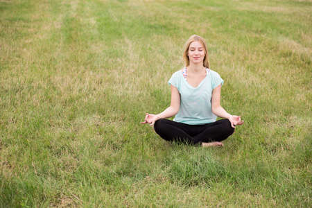 Image of girl sitting on grass enjoying summer outdoorの写真素材
