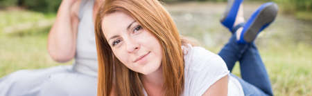 Beauty red hair woman lying on the grassの写真素材