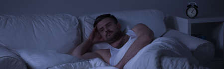 Sad man unable to sleep because of memories from past