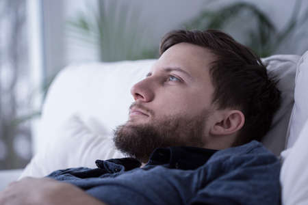 Portrait of pensive tired male unable to fall asleep