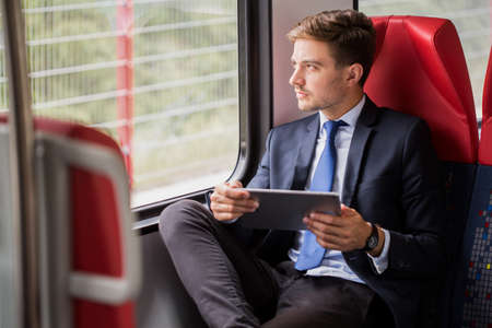 Image of male commuter in suit traveling by train Image of male commuter in suit traveling by train