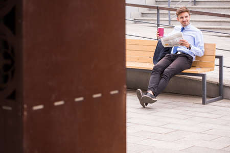 Image of male passenger drinking coffee on train stationの写真素材