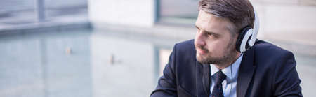 Businessman with headphones listening music at workの写真素材