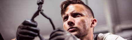 Male automotive technician working in repair shopの写真素材