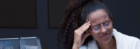 Panorama of overworked female with strong headacheの写真素材