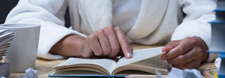 Panorama of educated girl reading academic manualの写真素材
