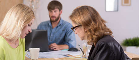 Panorama of two female designers discussing lucrative design contract