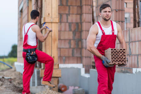 Two young workmen employed at construction siteの写真素材