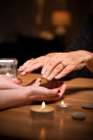 Old fortune teller sees a future from palms