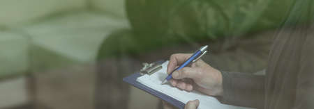 Writing in notepad - close-up of hand and penの写真素材