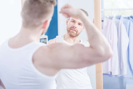 Image of narcissistic man taking photo of his bicepsの写真素材