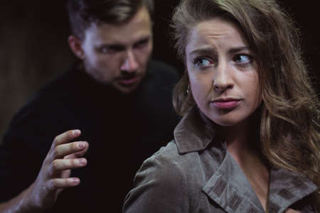 Young man is attacking terrified and scared woman