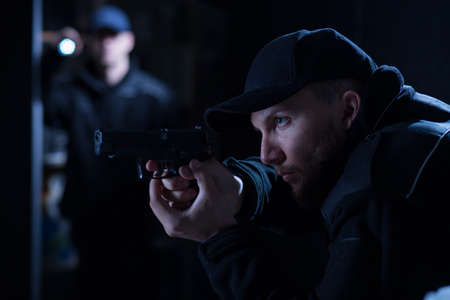 Police officer holding handgun during police intervention
