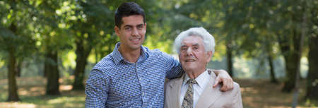Young man is walking around with his grandfatherの写真素材
