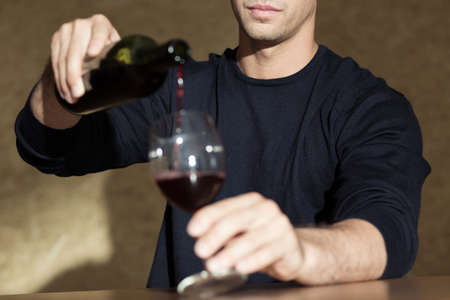 Addicted businessperson drinking wine alone at homeの写真素材