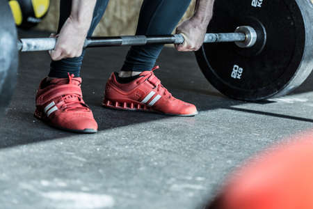 Man practicing weight lifting in the exercise roomの写真素材