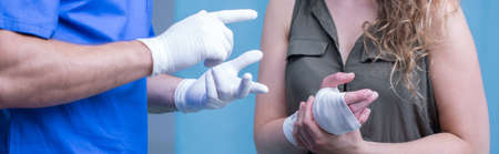 Panorama of doctor making recommendations for patient with broken handの写真素材