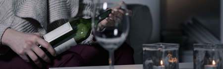 Woman opening half-empty bottle of red wineの写真素材