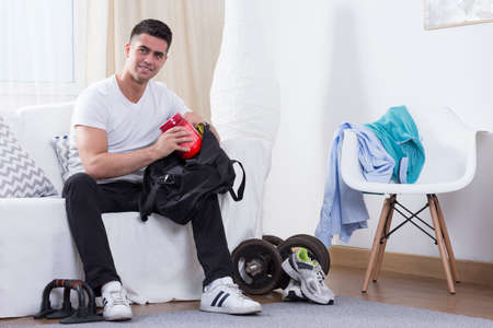 Sporty man packing protein powder to the bagの写真素材