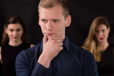 Macho and two beauty women in backgroundの写真素材