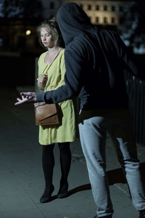 Strong aggressor wants to rip off woman's moneyの写真素材