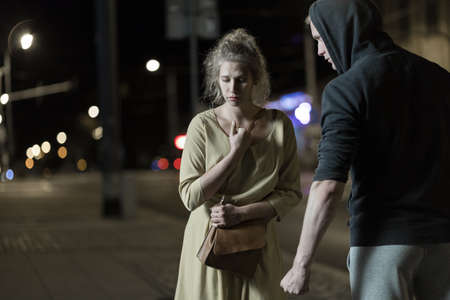 Strong man wants to rip off woman's bagの写真素材