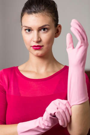 Perfect housewife is wearing pink rubber gloveの写真素材