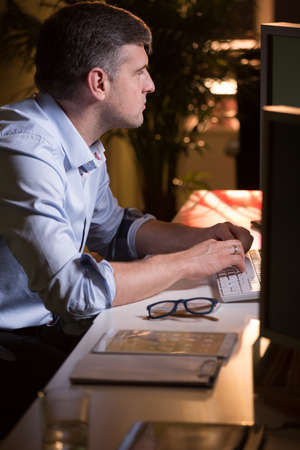 Focused businessman writing on keyboard in his office