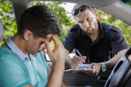 Man in a car and the policeman with traffic ticketの写真素材