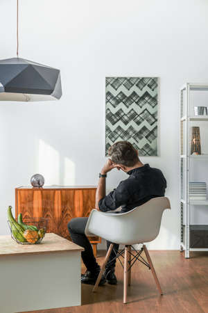 Man sitting on chair in bright flatの写真素材