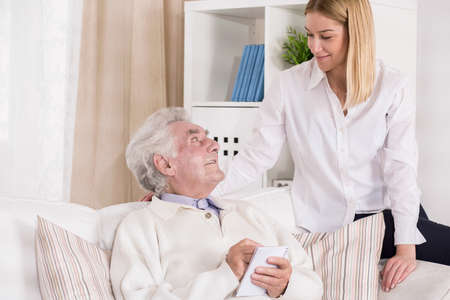 Picture of helpful granddaughter visiting her grandfather in rest home