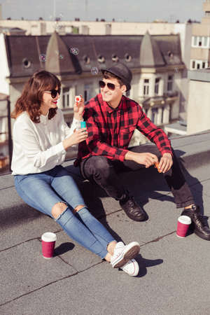 Couple drinking coffee in the city and blowing bubbles