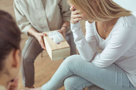 Young woman with emotional problems crying during psychotherapy