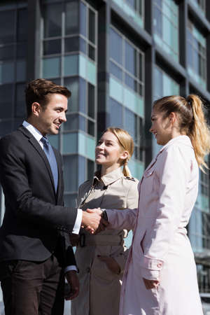 Young corporate employees standing near corporate building