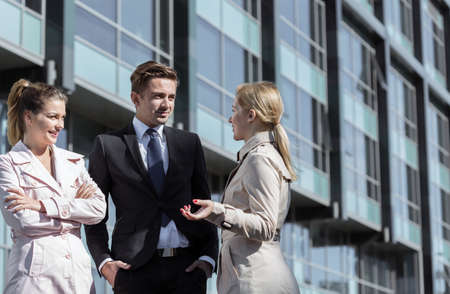 Corporate colleagues are talking outside their officeの写真素材