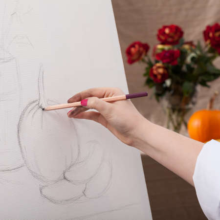 Woman draws a still life on a white canvasの写真素材