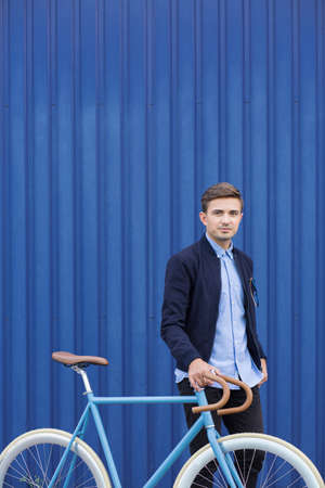 Active young businessman riding bicycle to workの写真素材