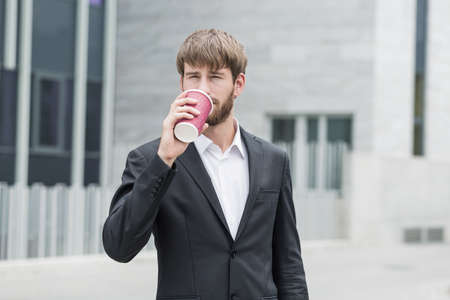 Young businessman is drinking coffee with relishの写真素材